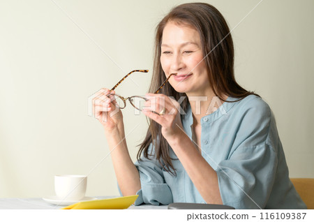 Senior woman holding glasses 116109387