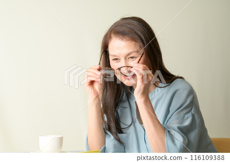 Senior woman holding glasses Senior woman holding glasses 116109388