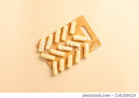 Top view of raw sweet bagels or twisted cookies with filling on wooden tray, frozen convenience food, bakery products background. Top view of raw sweet bagels or twisted cookies with filling on wooden tray, frozen convenience food, bakery products background. 116109529