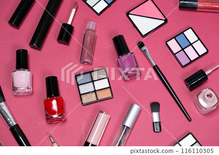 Various decorative cosmetics and brushes on a pink background, top view. 116110305