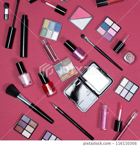 Various decorative cosmetics and brushes on a pink background, top view. 116110308