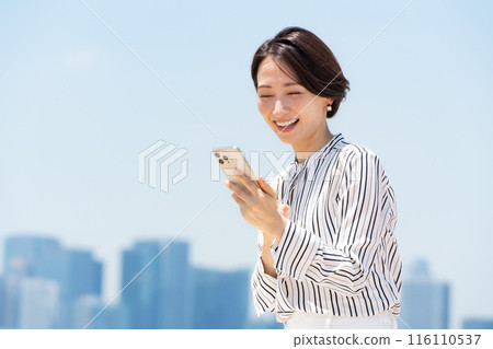 A woman watching a smartphone A woman watching a smartphone 116110537