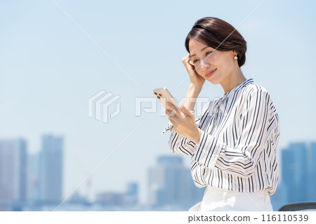 A woman watching a smartphone 116110539