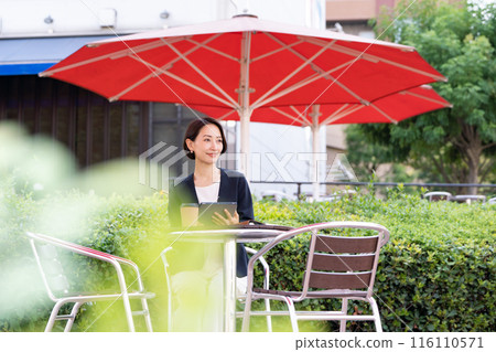 A woman working at an open cafe 116110571