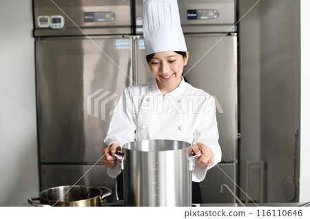 Young Asian female chef cooking in a stockpot 116110646