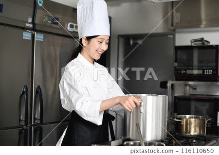 年輕的亞洲女廚師在鍋裡做飯 116110650