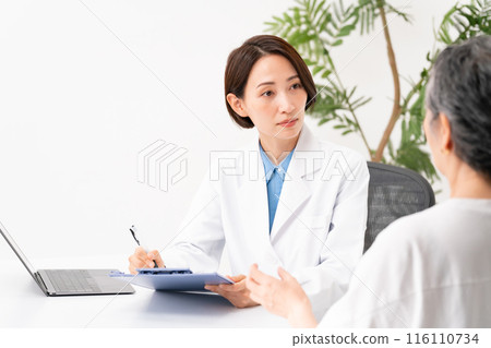 Doctor and patient interviewing face-to-face 116110734