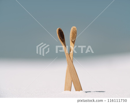 Eco-Friendly Bamboo Toothbrushes Standing on White Sand Eco-Friendly Bamboo Toothbrushes Standing on White Sand 116111730