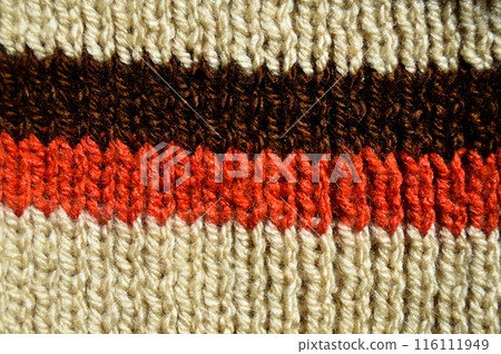 Handmade knitted fabric brown red and beige wool background texture 116111949
