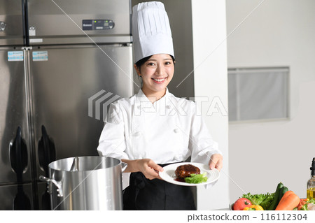 供應肉類菜餚的年輕亞洲女廚師 供應肉類菜餚的年輕亞洲女廚師 116112304