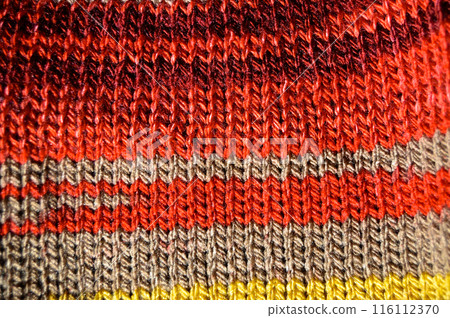 Handmade knitted fabric red yellow and beige wool background texture Handmade knitted fabric red yellow and beige wool background texture 116112370