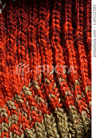 Handmade knitted fabric red and beige wool background texture 116112385