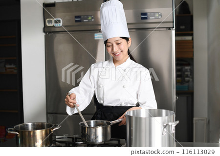 Young asian female chef cooking in a pot 116113029
