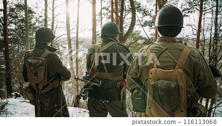 Back View On American Infantry Soldier Watch For Bright Sun At Winter Day. Group Of Usa Soldiers Armed Of Assault Rifle. Usa Army Soldiers Of World War Ii 116113068