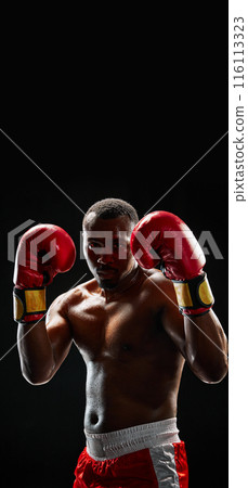 Close-up of a muscular athlete, ready for combat, with a focused and intense look isolated on black background Close-up of a muscular athlete, ready for combat, with a focused and intense look isolated on black background 116113323