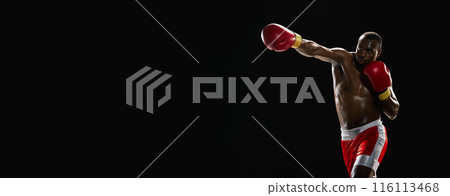 Dynamic pose. African-American muscular man with athletic strong body, boxer in motion isolated on black background Dynamic pose. African-American muscular man with athletic strong body, boxer in motion isolated on black background 116113468