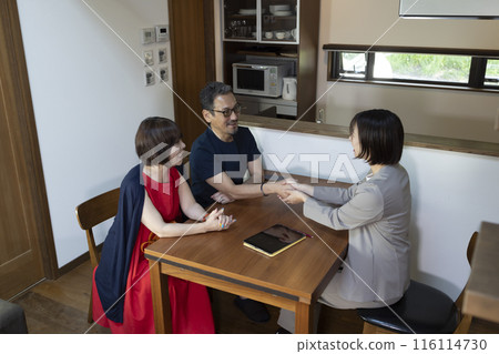 A businessperson giving a tour to a middle-aged couple 116114730