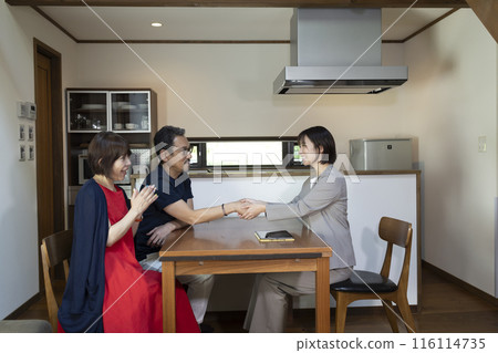 A businessperson giving a tour to a middle-aged couple A businessperson giving a tour to a middle-aged couple 116114735