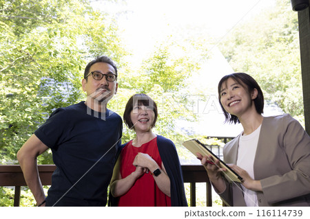 A businessperson giving a tour to a middle-aged couple A businessperson giving a tour to a middle-aged couple 116114739