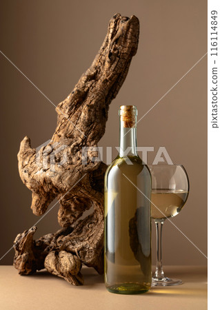 White wine and old snag on a beige background. White wine and old snag on a beige background. 116114849