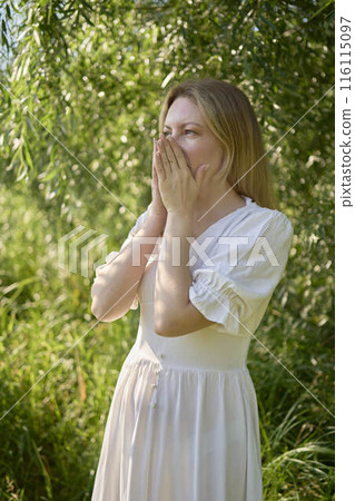 beautiful young artist in a white dress among the trees on the river bank 116115097
