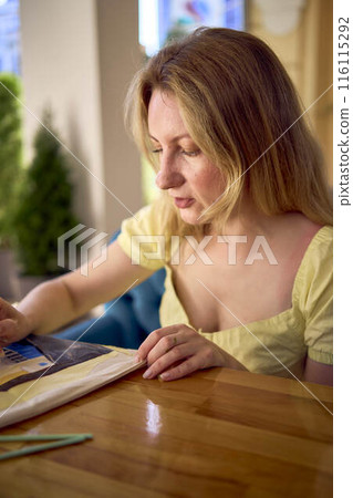a beautiful young artist in a yellow dress paints a customized shopping bag a beautiful young artist in a yellow dress paints a customized shopping bag 116115292