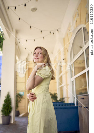 a beautiful young artist in a yellow vintage dress poses a beautiful young artist in a yellow vintage dress poses 116115320