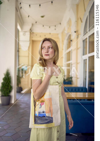 beautiful young artist in yellow dress posing with hand painted customized shopping bag beautiful young artist in yellow dress posing with hand painted customized shopping bag 116115346