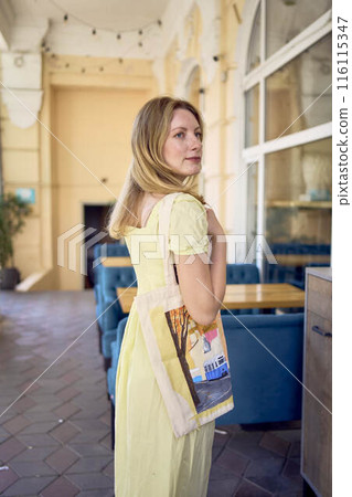 beautiful young artist in yellow dress posing with hand painted customized shopping bag beautiful young artist in yellow dress posing with hand painted customized shopping bag 116115347