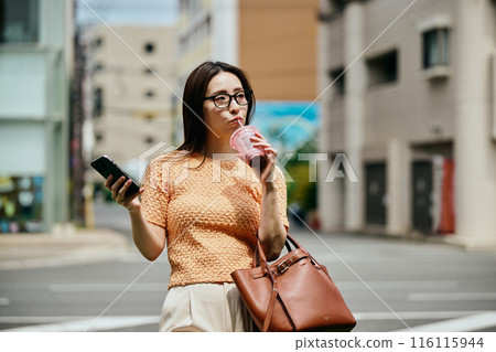 A young woman operating a smartphone 116115944