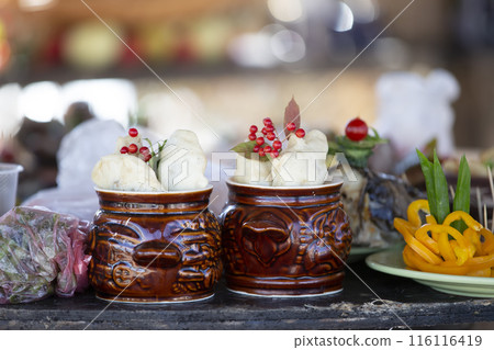 Two clay peas with rustic food.There are pots of potatoes on the table. Two clay peas with rustic food.There are pots of potatoes on the table. 116116419