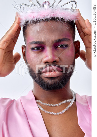 Serious young transgender black man lgbt being as woman posing in crown and pink shirt Serious young transgender black man lgbt being as woman posing in crown and pink shirt 116116488