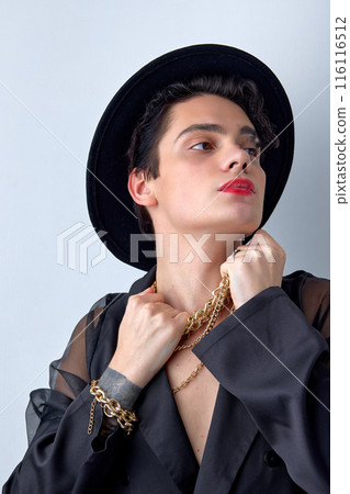 Close-up Portrait of guy grabbed the chain, wearing chic party clothes, isolated 116116512