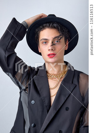 Male makeup look. Portrait of sexy brunette man in black stylish wear, posing 116116513