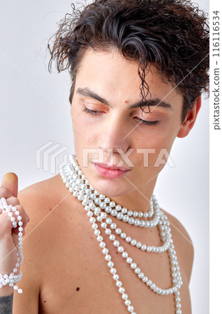 Portrait of shirtless naked man with tattoo and natural make-up, with chain necklace Portrait of shirtless naked man with tattoo and natural make-up, with chain necklace 116116534