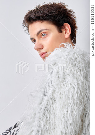 Profile portrait of young man in coat with natural make up posing as professional model Profile portrait of young man in coat with natural make up posing as professional model 116116535