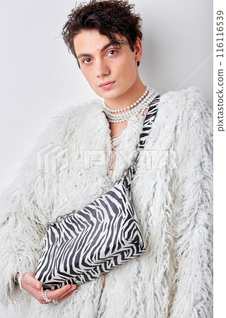 Portrait of man in white fluffy coat posing with handbag isolated over white background Portrait of man in white fluffy coat posing with handbag isolated over white background 116116539