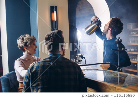 funny barmen entertaining his guests funny barmen entertaining his guests 116116680