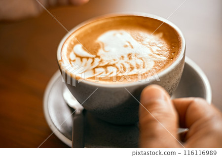 a cup of hot latte art coffee on wooden table a cup of hot latte art coffee on wooden table 116116989