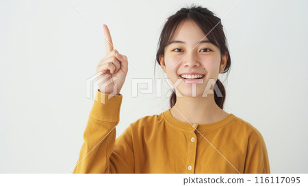 一位年輕的日本女性指著微笑的肖像 116117095
