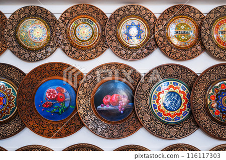 handmade Uzbek wooden gift plates with wood carvings hand-painted traditional patterns in souvenir shop of Uzbekistan in Tashkent 116117303