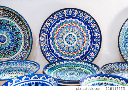 Arabic Uzbek handmade ceramic plates with hand-painted with a traditional East Asian colorful pattern in a pottery workshop in Uzbekistan Arabic Uzbek handmade ceramic plates with hand-painted with a traditional East Asian colorful pattern in a pottery workshop in Uzbekistan 116117355