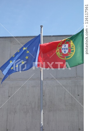 Portuguese and European Union flags waving against a building 116117561
