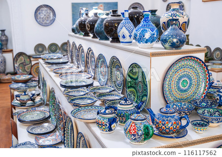 Uzbek handmade ceramic plates and tableware with hand-painted traditional Asian colorful patterns in souvenir store Uzbek handmade ceramic plates and tableware with hand-painted traditional Asian colorful patterns in souvenir store 116117562