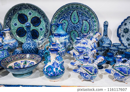 Asian Uzbek ceramic plates, jugs and dishes hand-painted in oriental market in Uzbekistan 116117607