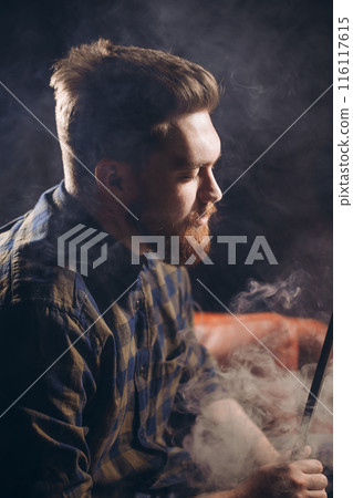 drunken young man smoking at the bar 116117615