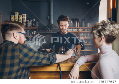 young stylsh man taking a glass from barmen young stylsh man taking a glass from barmen 116117657