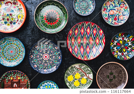 traditional oriental Uzbek ceramic plates hand painted on dark background 116117664
