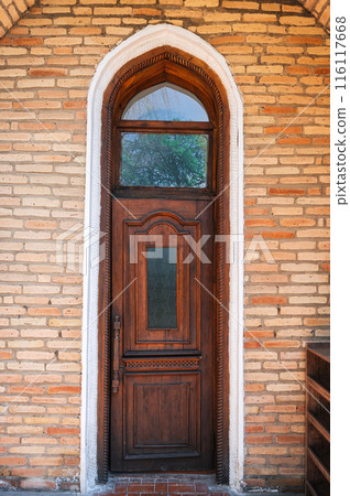 ancient carved wooden door to student room in Kukeldash madrasah with traditional pattern ornaments in Uzbekistan in Tashkent 116117668
