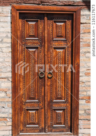 Uzbek carved wooden door to Kukeldash Madrasah with pattern decorated with oriental arabic carved ornaments in Uzbekistan in Tashkent 116117673